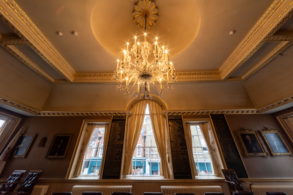 Photo of the Council Chamber, facing west, focused on the chandelier and main windows