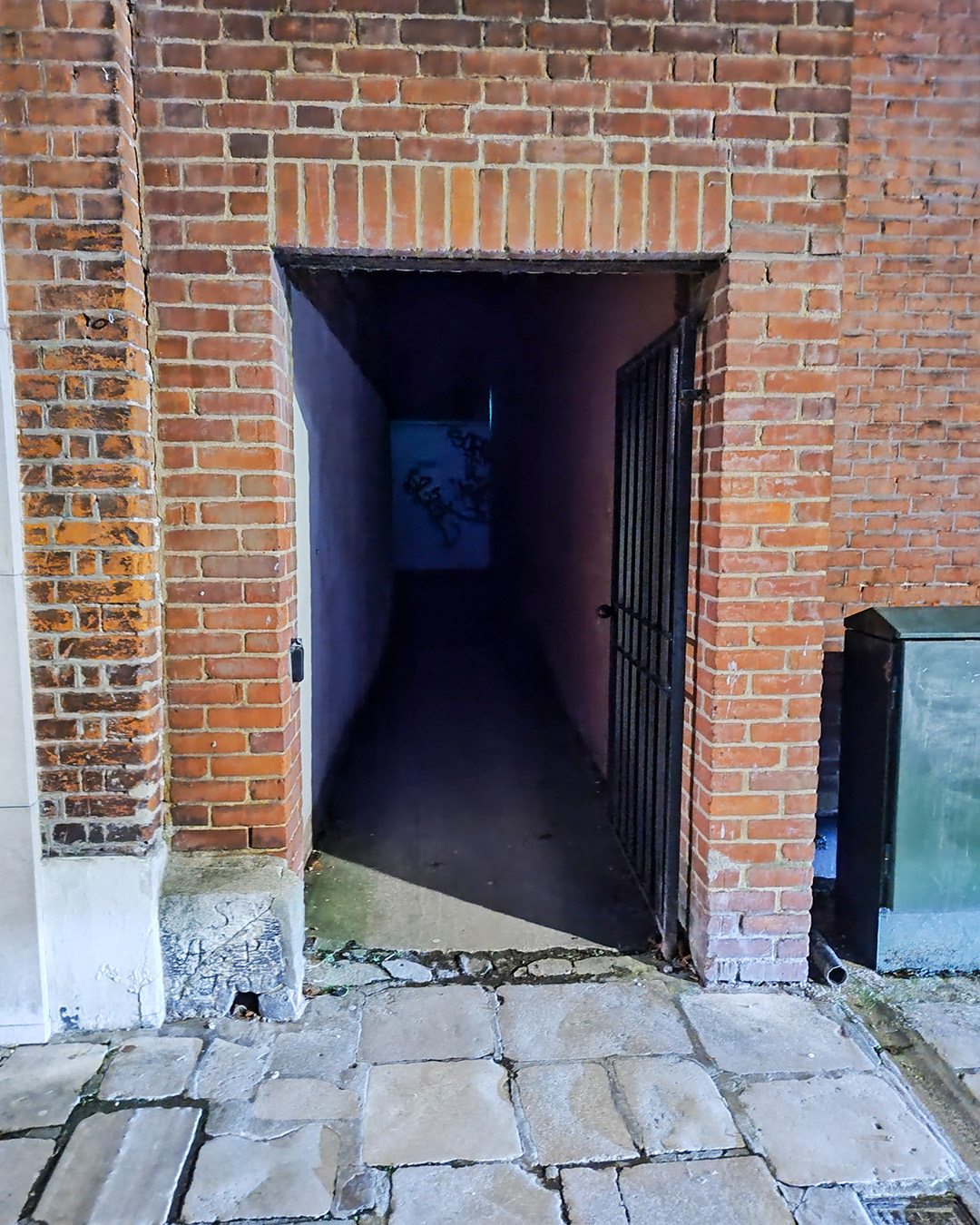 Dark alleyway in the City Centre leading to a car park.